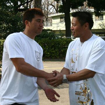 野球評論家の黒木知宏氏（左）とガッチリ握手する岩村
