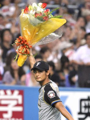オリックス戦で通算１０００投球回を達成し、花束を掲げる日本ハムのダルビッシュ