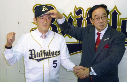 オリックスの入団記者会見で、村山良雄球団本部長（右）と握手を交わす平野恵一内野手