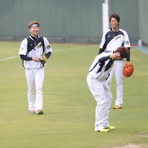 西（手前）を相手にキャッチボールをしながら笑う金子（左）と前田健