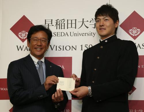日本ハム・栗山監督（左）から交渉権確定のカードを手渡されるドラフト１位の早大・有原