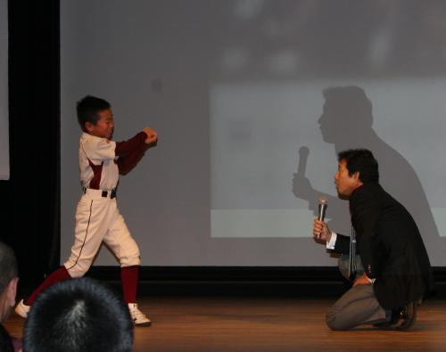 北海道・由仁町で講演を行った日本ハム・栗山監督は舞台に野球少年を上げて、「打撃を教えて！」と見本をみせてとせがむ