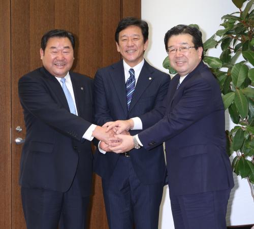 フォトセッションでポーズをとる（左から）竹田球団社長、栗山監督、末沢オーナー