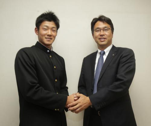 日本ハム・大渕アマスカウトディレクター（右）はドラフト２位の早大・石井と握手