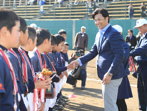 少年野球大会の表彰式で選手にメダルを授与する巨人・高橋監督