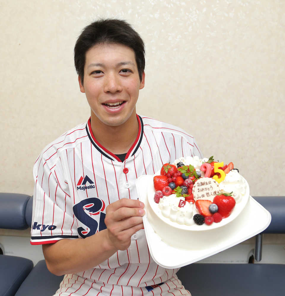 誕生日ケーキを手に笑顔の山田