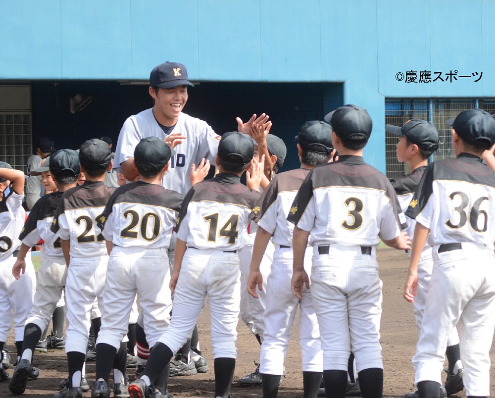 地元チームの少年らとハイタッチを交わす明渡（Ｃ）慶應スポーツ新聞界