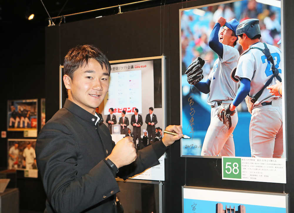 野球報道写真展を見学した宮台は六大学野球時代の写真にサインを入れる