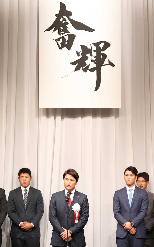 奮輝のチームスローガンが掲げられる中、開幕戦のスタメンを公表した高橋監督（後方左から岡本、坂本勇、吉川尚）　　　　　　　　　　　　　　　　　　　　　　　　　　　　　　　　　　　　　　　　　　　　　　　　　　　　　　　　　　　　　　　　　　　　　　　　　　