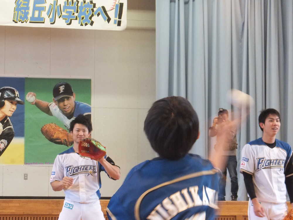 札幌市内の緑丘小学校を訪問し、児童とキャッチボールを行う日本ハム・西川（左）と太田
