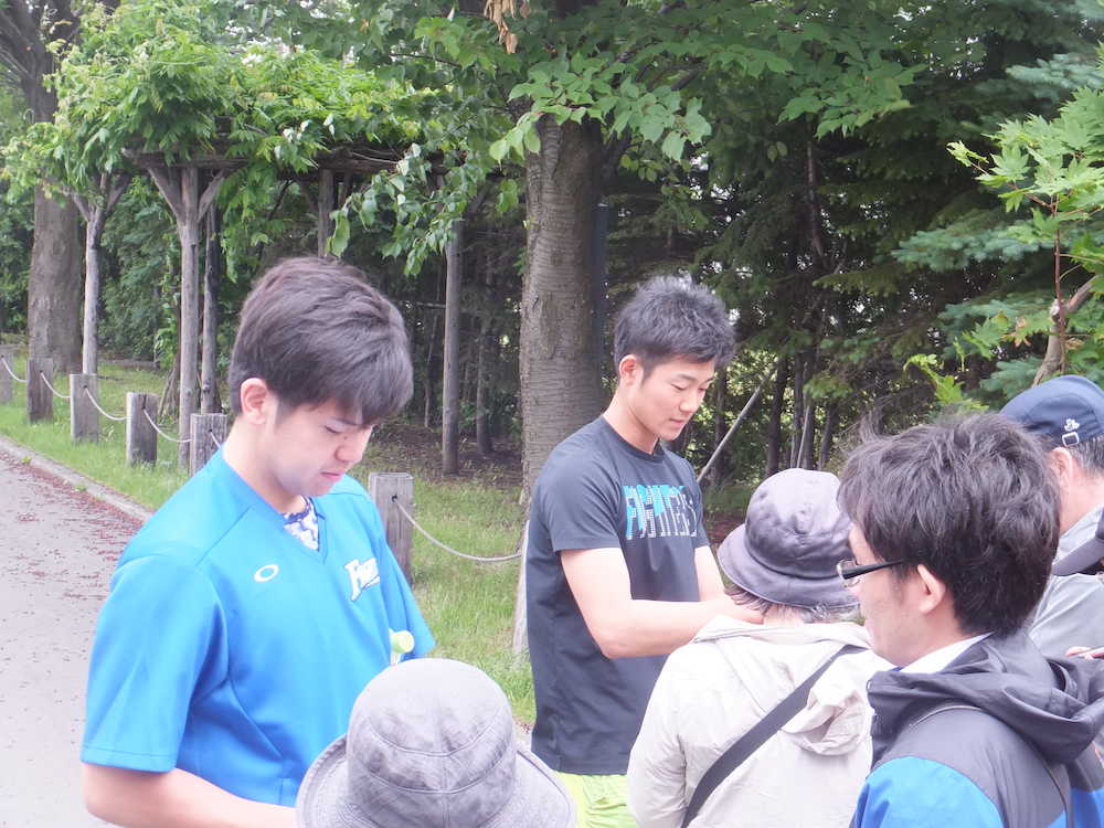 札幌市内の室内練習場で自主トレを行い、ファンにサインする日本ハムの清水（左）と石井一