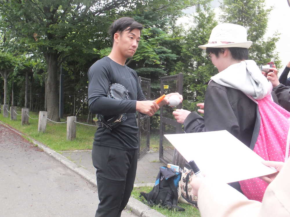 札幌市内の室内練習場で自主トレを行い、その後にファンにサインする日本ハム・斎藤