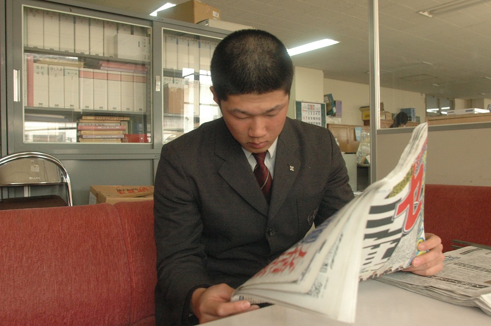 東日本大震災の被害を伝えるスポニチを食い入るように読む聖光学院・歳内