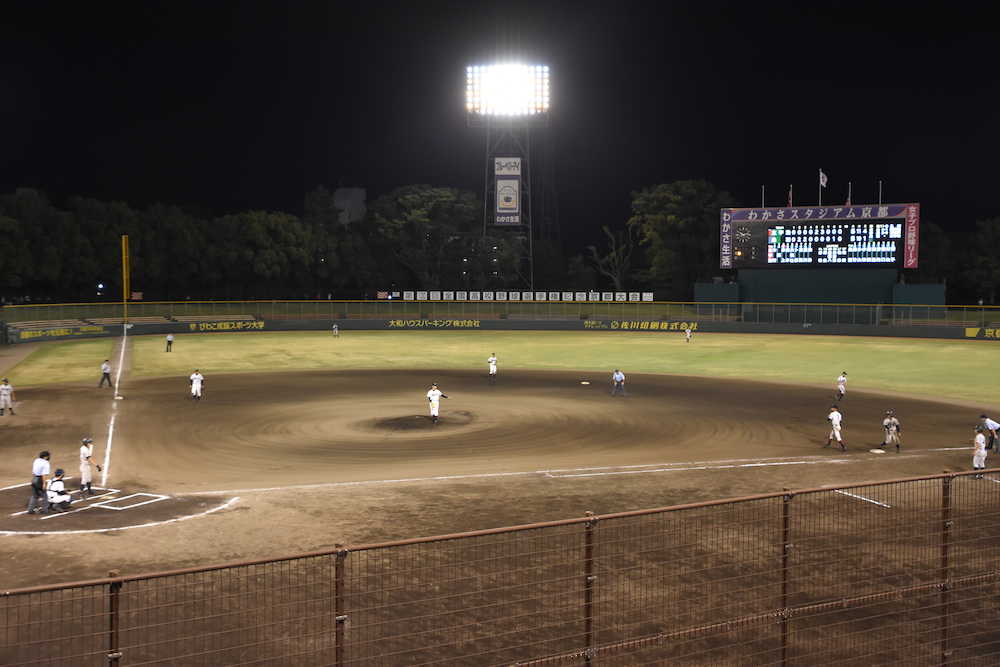 高野・京都大会第４試合　ナイター照明の下、試合をする選手たち（１０回表）
