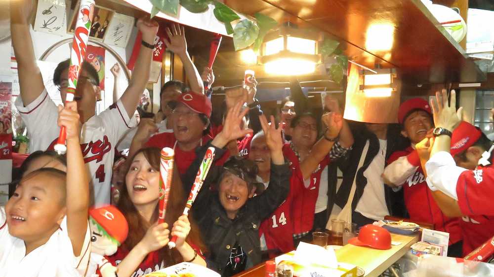 広島の３連覇を喜ぶ神戸・長田の居酒屋「Ｖ３カープ」のファン。（中央左から２人目が店主の菊池貴弘さん）