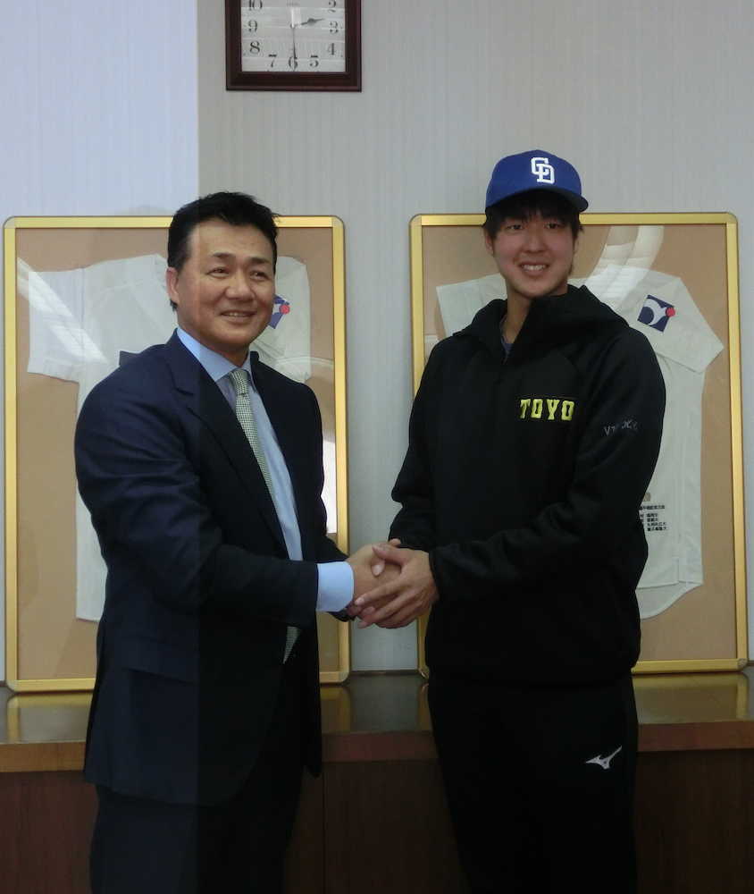 指名あいさつに訪れた中日・与田新監督（左）とがっちり握手するドラフト２位の東洋大・梅津