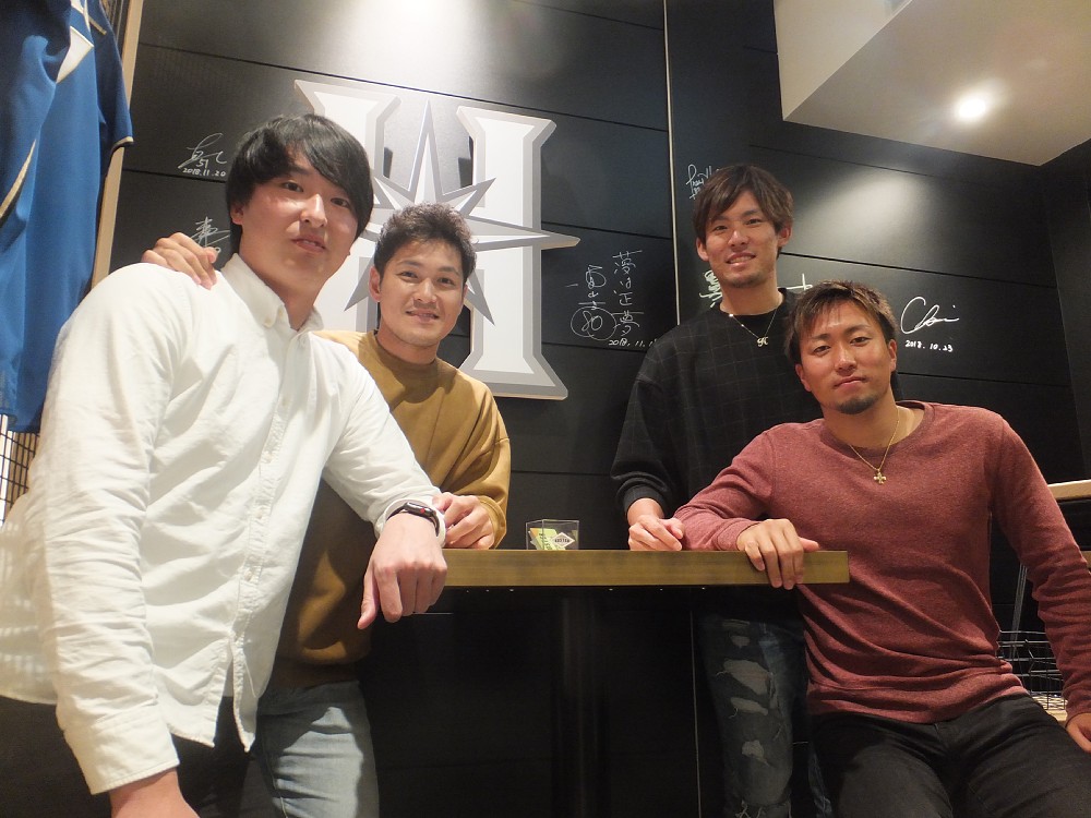 新千歳空港内のレストランでサインした壁を背に記念撮影した日本ハムの（左から）石川直、鍵谷、高梨、井口