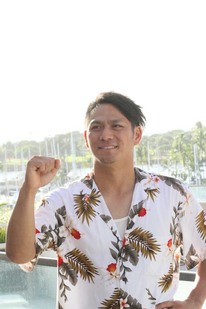 ホテルから見えるハワイの景色を背にポーズを決める田中