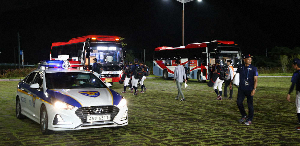 ＜日本代表U－18練習＞パトカーが待つ駐車場でバスに乗り込む選手たち（撮影・島崎忠彦）