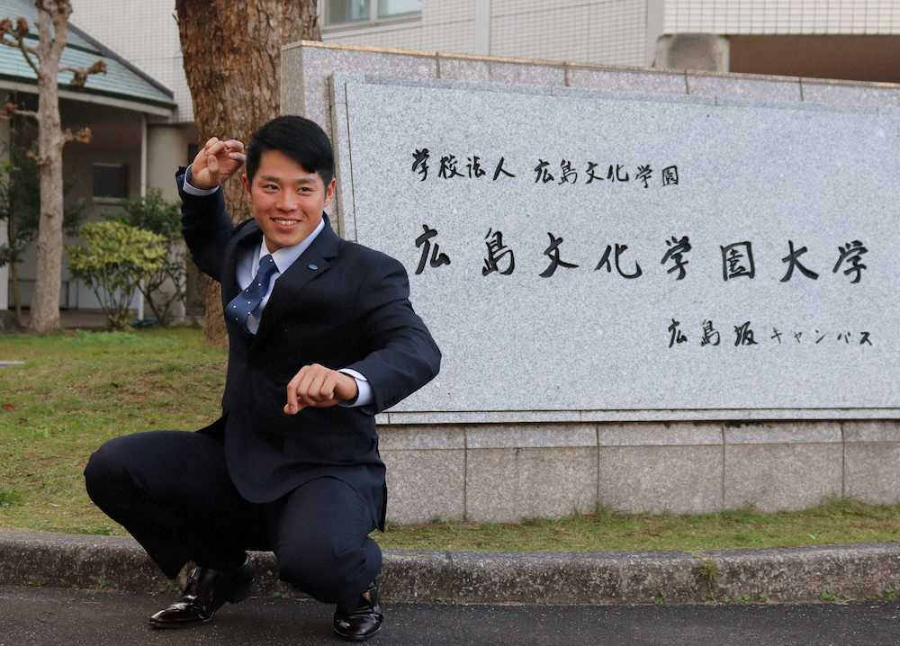 広島文化学園大初のプロとなった梅林は、校名の石碑前で送球のポーズ