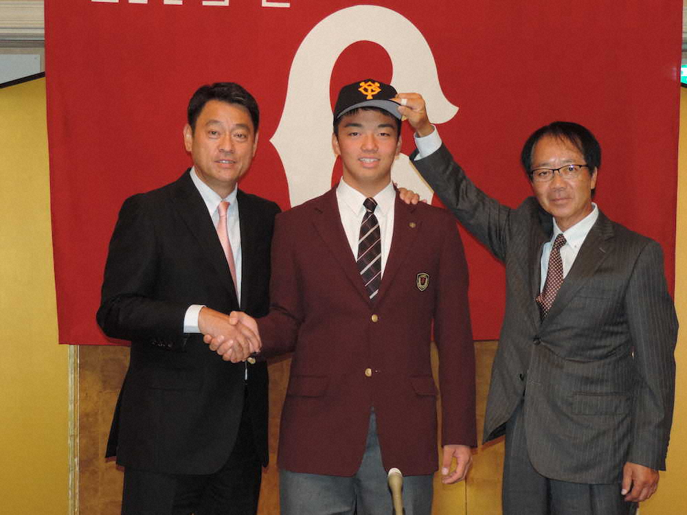 巨人にドラフト3位指名された常総学院の菊田拡和内野手（中央）は球団と仮契約。左は長谷川国利スカウト部長、右は内田強スカウト　　　　　　　