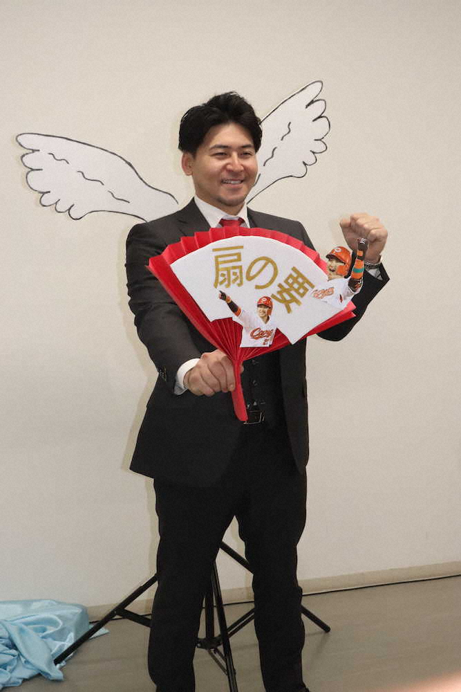 契約交渉を終え、翼の名前にかけた模型の前でポーズを決める広島・会沢