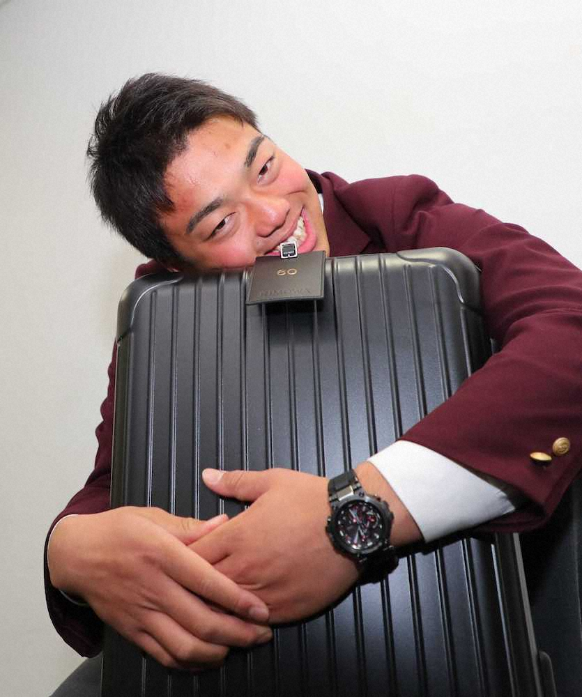 ＜巨人入寮＞持参した腕時計とスーツケースを手に笑顔を見せるドラフト3位の菊田(撮影・木村　揚輔)