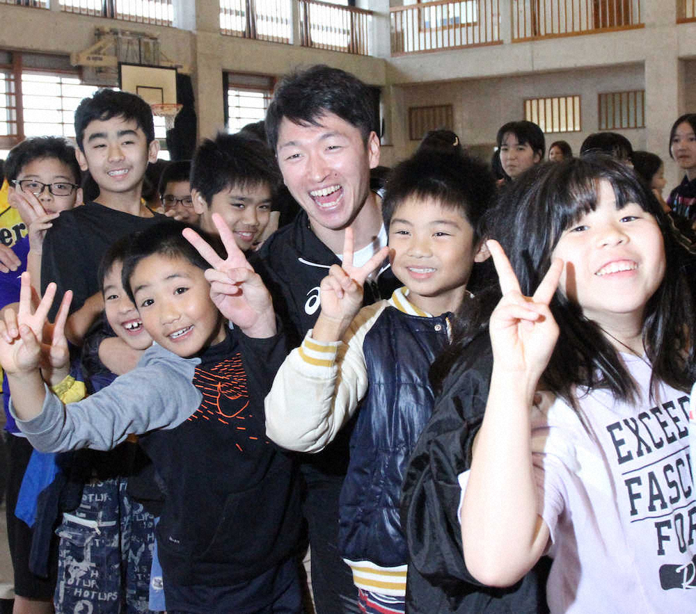 宜野座村の小学生と触れ合い、笑顔でピースサインをする近本（中央）（撮影・平嶋　理子）　　　　　　　　　　　　　　　　　　　　　　　　　　　　　　　　　　　　