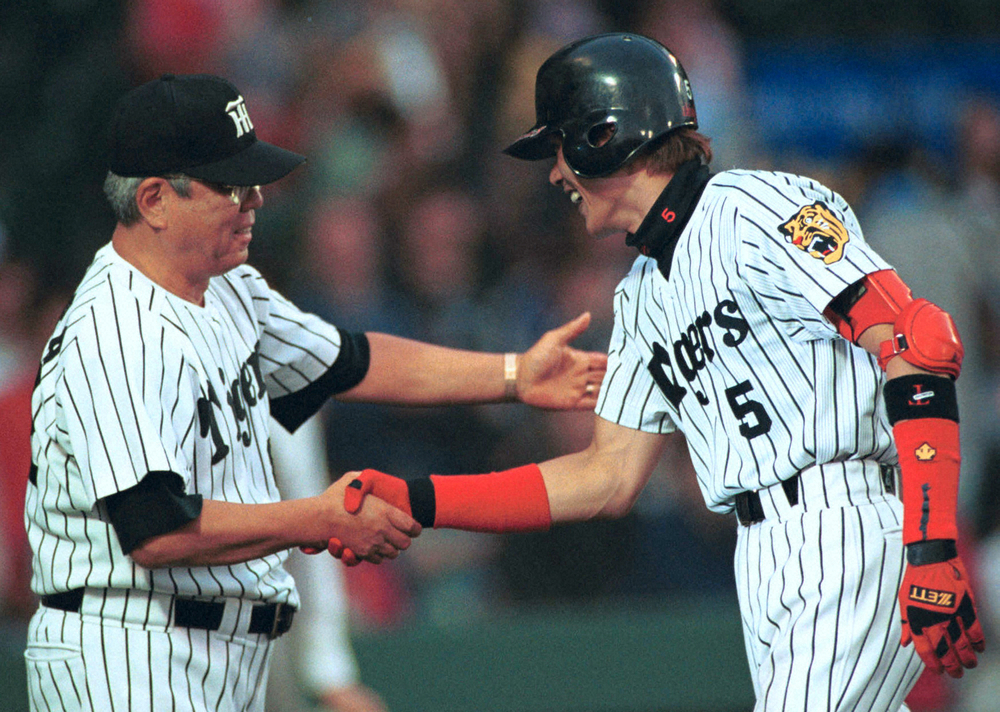 本塁打を放った新庄剛外野手（右）を握手で迎える阪神・野村克也監督（2000年）