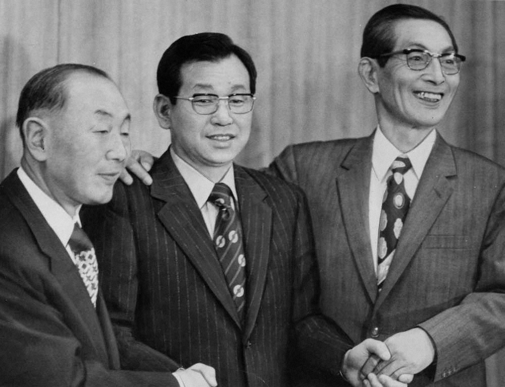 1974年10月25日、監督就任会見で握手を交わす（左から）阪神・野田忠オーナー、吉田新監督、長田代表
