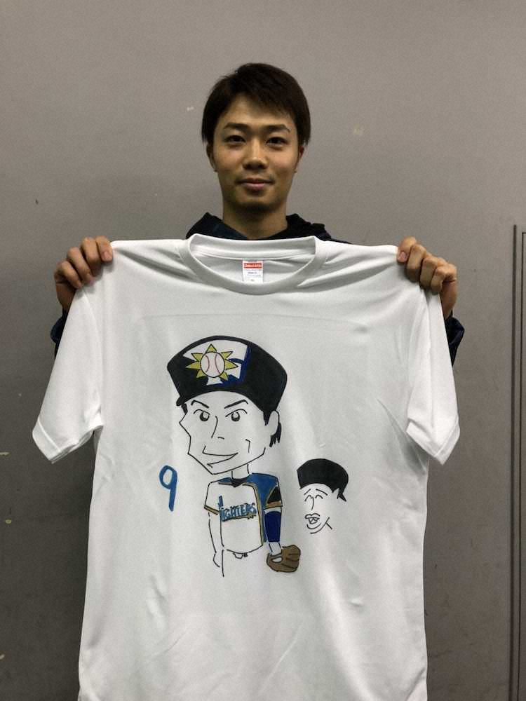 自身の似顔絵がイラストされたTシャツを持つ日本ハム・中島（球団提供）