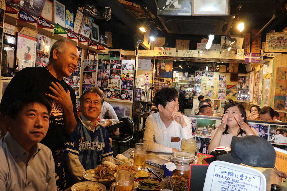 居酒屋「あぶさん」で来店客と試合観戦しながら談笑する石井店長（左から2人目）