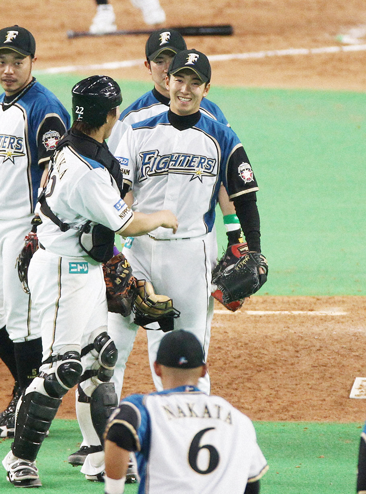 2012年3月30日、日本ハム・斎藤佑樹（中央）は、西武との開幕戦で完投勝利を飾り、笑顔を見せる