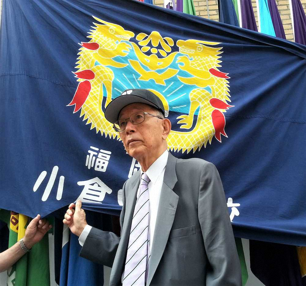 甲子園球場前に歴代優勝校が並ぶなか、母校・小倉の校旗を手にする福嶋一雄さん　（2013年8月15日）