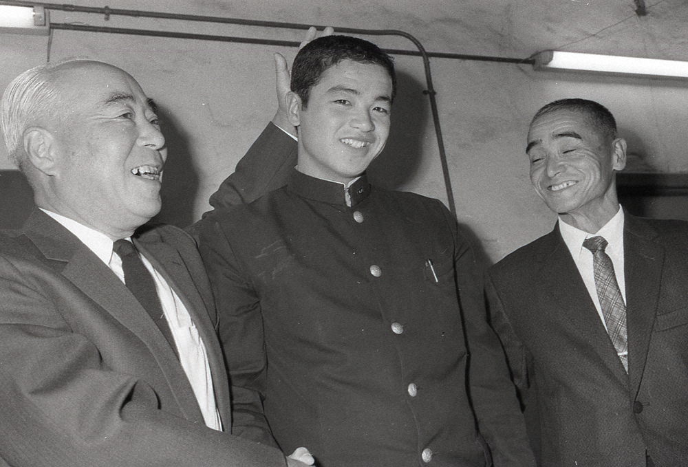 入団発表で阪神・戸沢一隆球団社長（左）から頭をなでられる川藤幸三氏。（右）は父・川藤甚之助氏。
