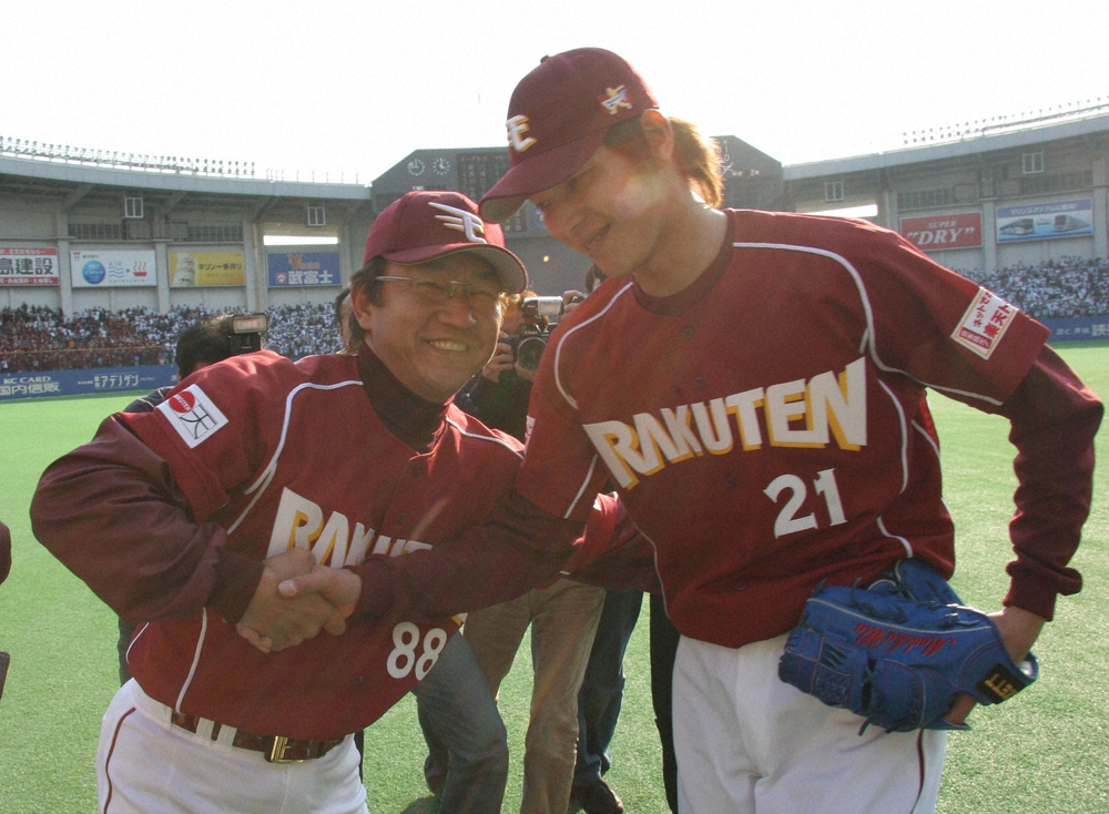 2005年3月26日のロッテ戦で9回1失点の完投で球団初勝利ｗ挙げた先発の岩隈（右）とガッチリ握手を交わす楽天の田尾安志監督。（撮影：三島英忠）