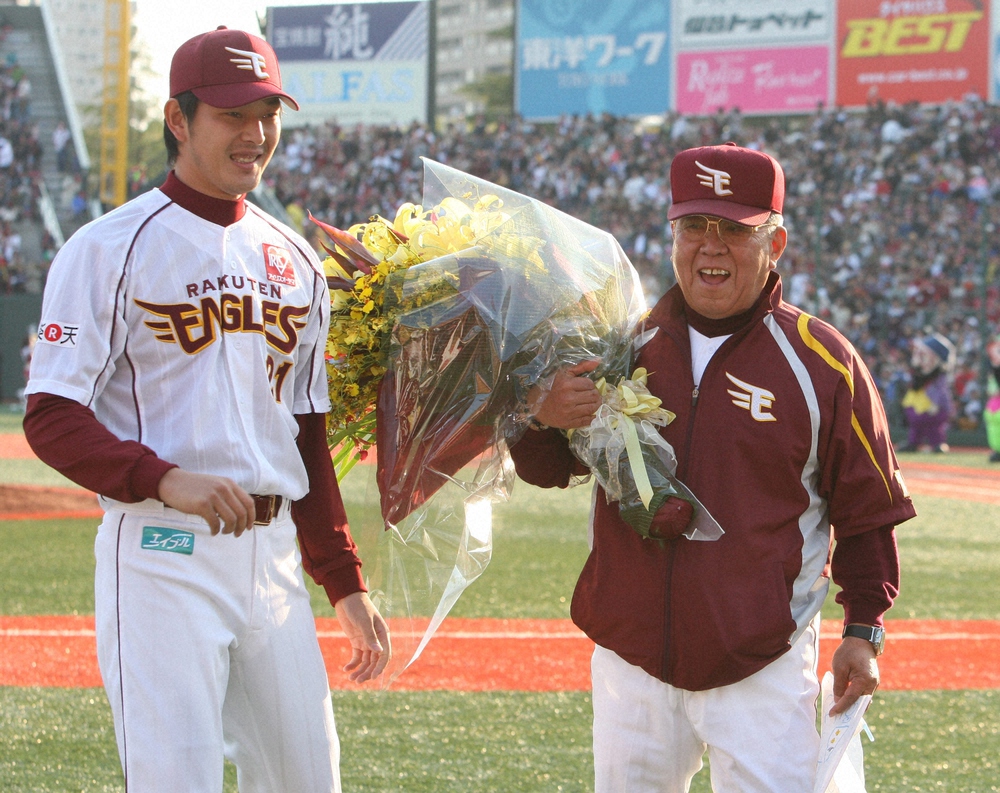 09年、史上5人目の監督1500勝を達成した野村監督（右）に花束を渡す岩隈