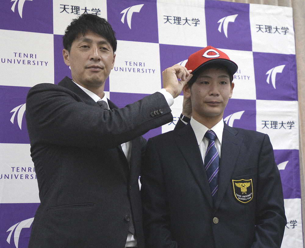 鞘師智也スカウト（左）から帽子をかぶせてもらう広島ドラフト2位の天理大・森浦大輔