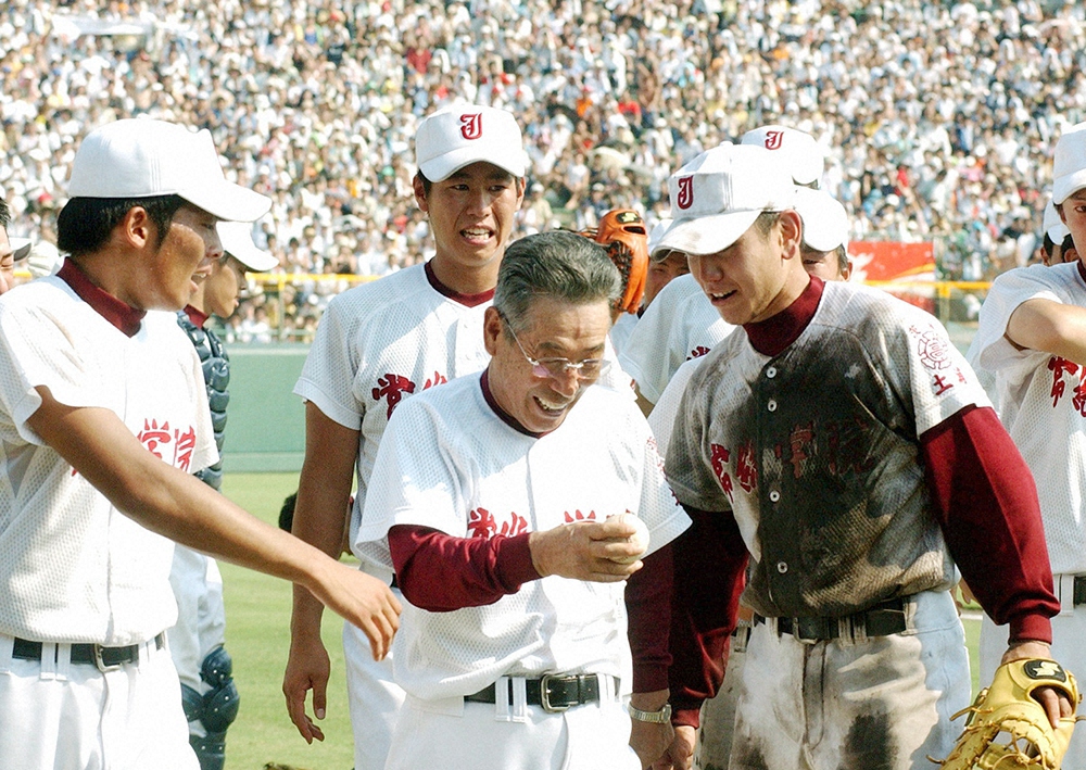 2003年夏の甲子園で優勝した常総学院・松林主将（前列右）からウイニングボール受け取る木内監督（同中央）