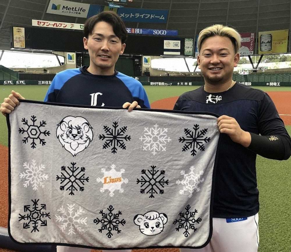 寄贈するブランケットを手に記念撮影する西武・源田（左）と森（球団提供）