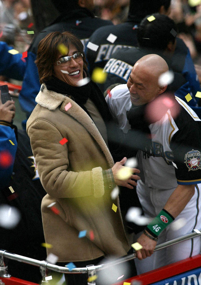 2006年の日本一パレードで、森本氏（右）と笑顔で抱き合う私服姿の新庄氏