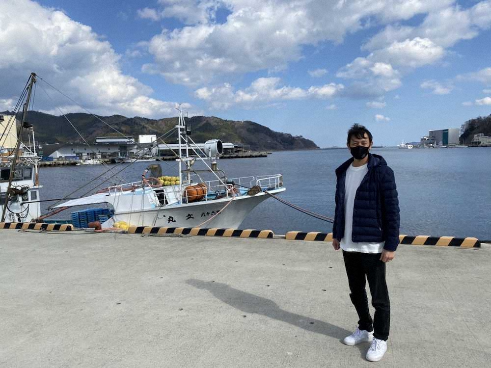 女川町の海をバックに写真におさまる岩隈久志氏