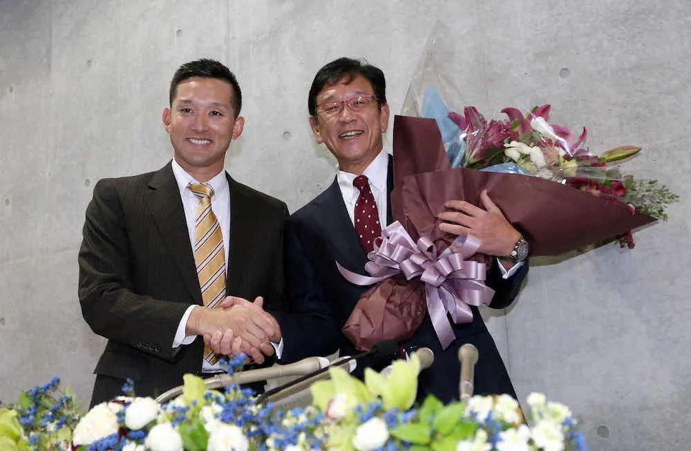 ＜日本ハム＞退任会見のサプライズで杉谷（左）から花束が贈られ笑顔で写真に納まる栗山監督（右）（撮影・高橋茂夫）