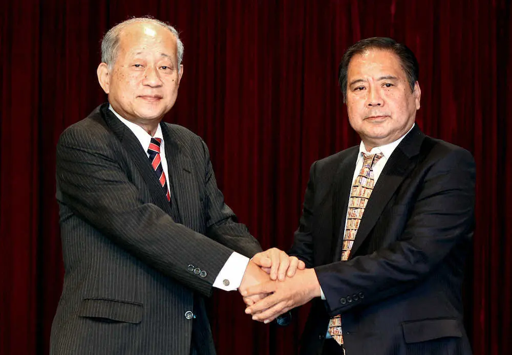 握手をかわす日本高野連の新しい会長に決まった宝馨さん（右）と退任する八田英二会長（代表撮影）