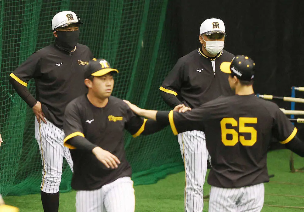 ウォーミングアップする選手たちをを見守る北川コーチ（左）と藤井康コーチ