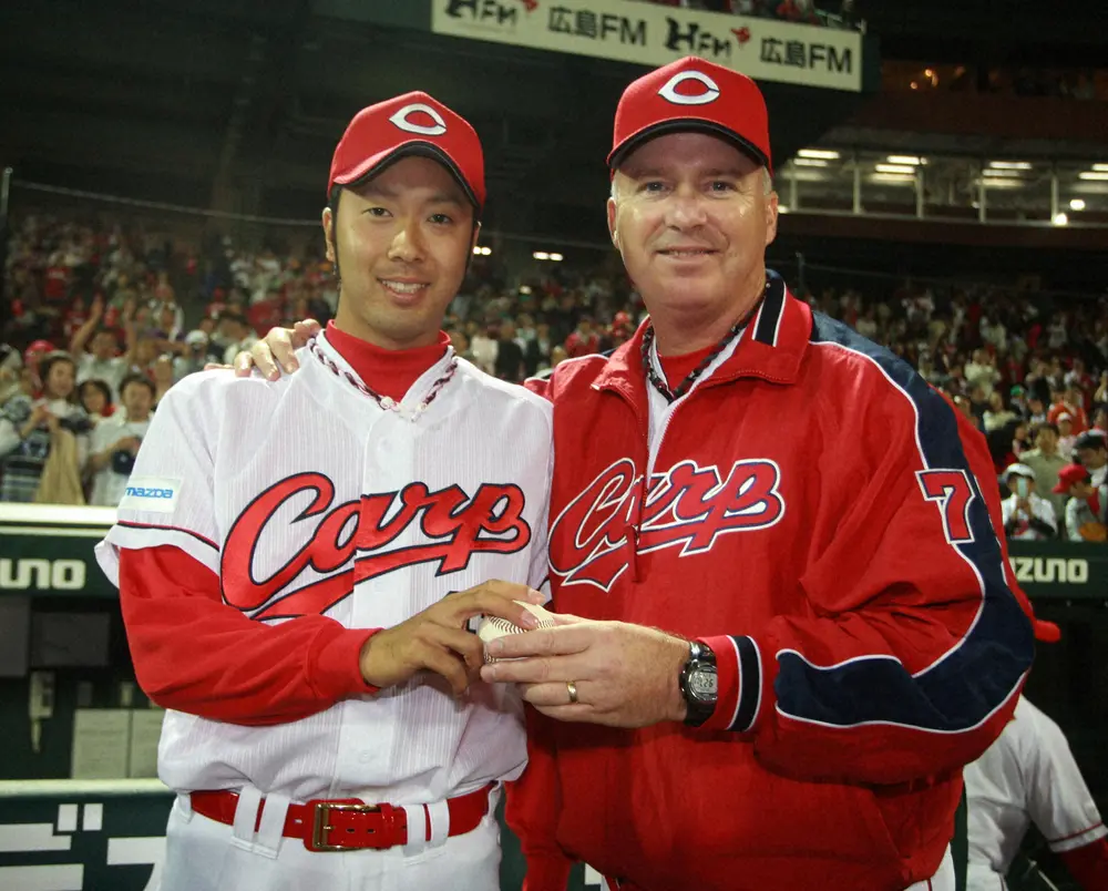初勝利のウイニングボールを手に、ブラウン監督と記念写真に収まる小松剛さん