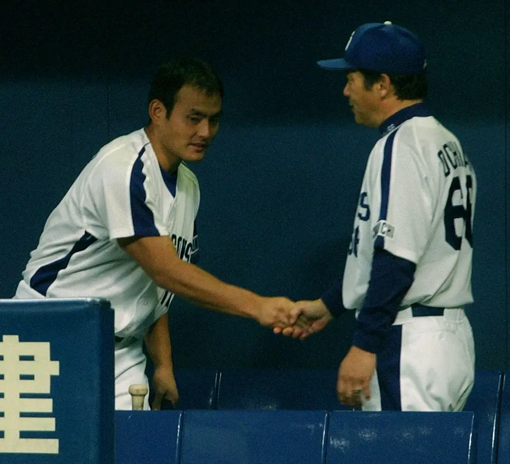 2004年、落合監督（右）とがっちりと握手する14勝目を挙げた先発の川上憲伸