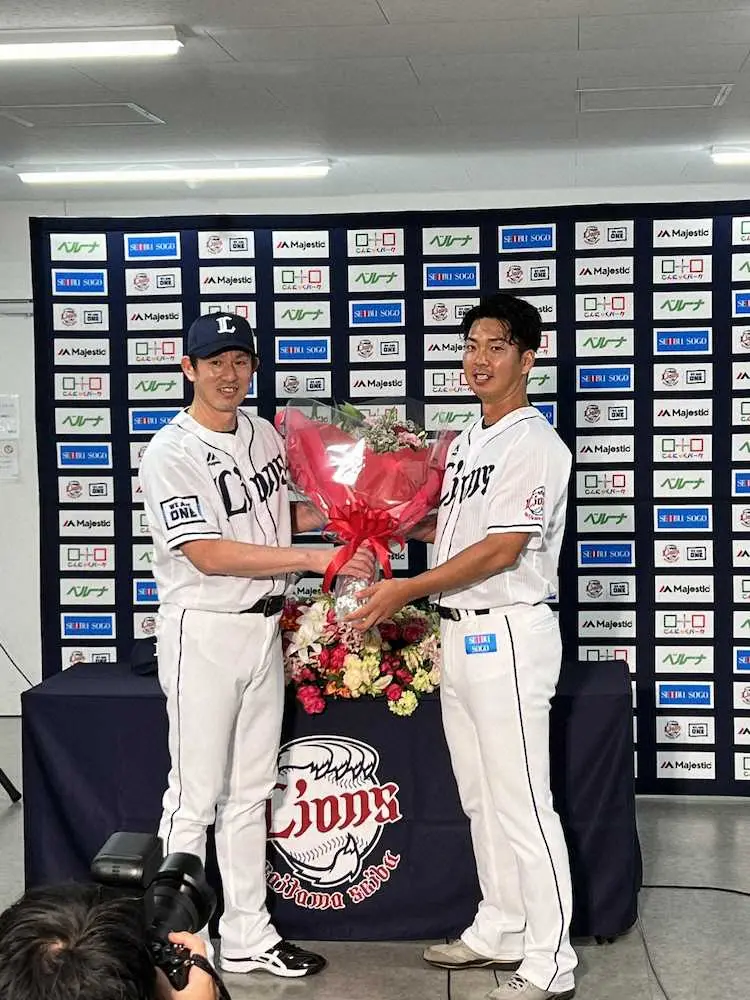 十亀（右）は引退会見で、豊田投手コーチから花束を渡される