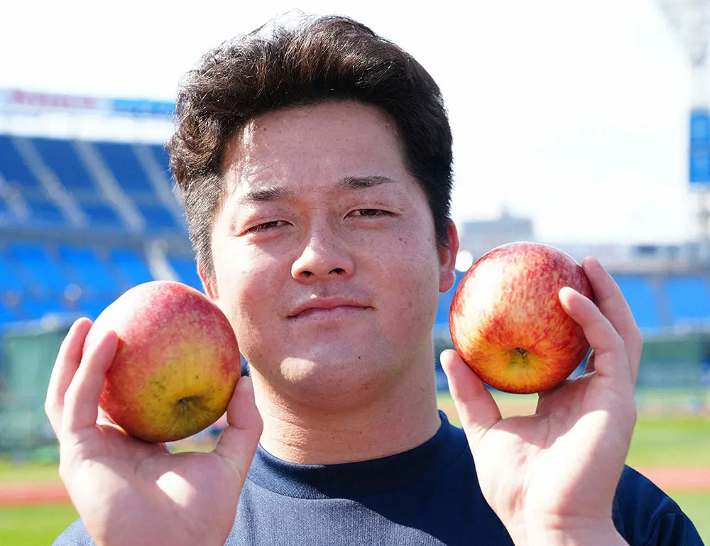 長野県産のリンゴを手に笑顔の牧（撮影・島崎　忠彦）