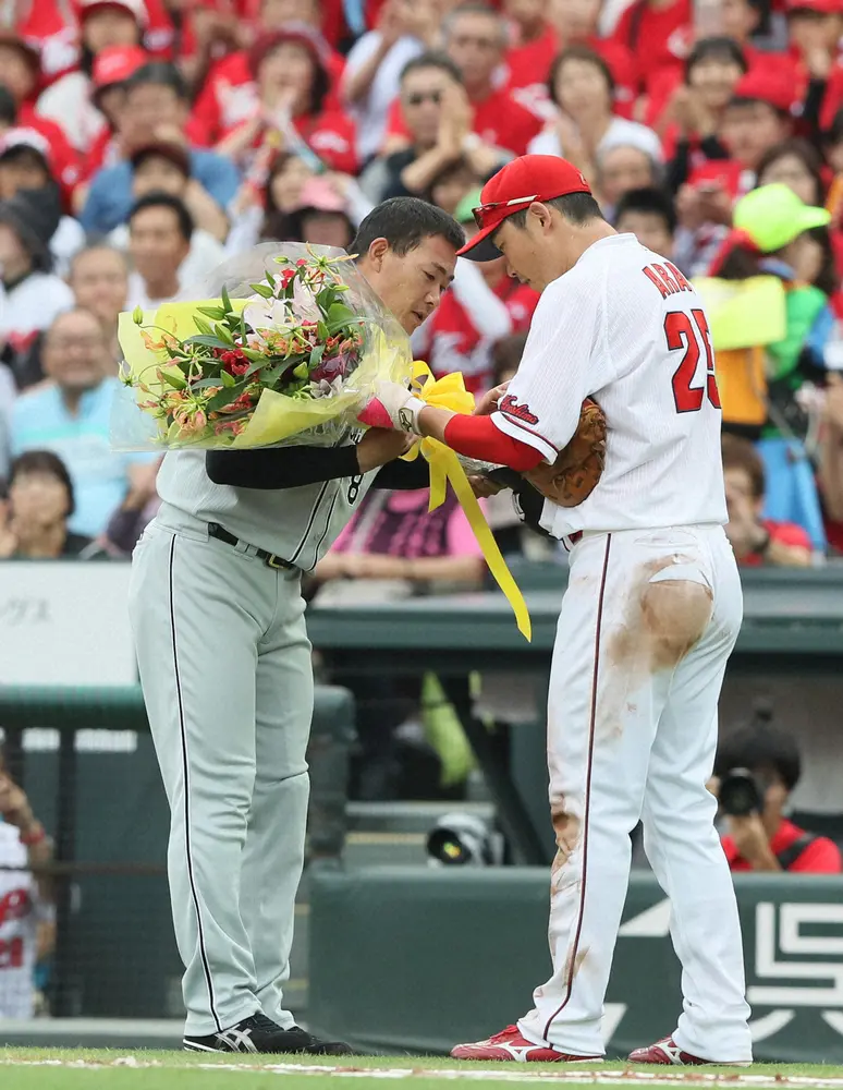 2016年6月25日の広島戦で、福留は日米通算2000安打を達成し新井貴浩（右）から花束を受け取る